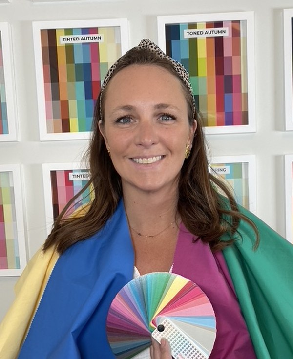 After: the client draped in colors from her palette, holding her swatch fan