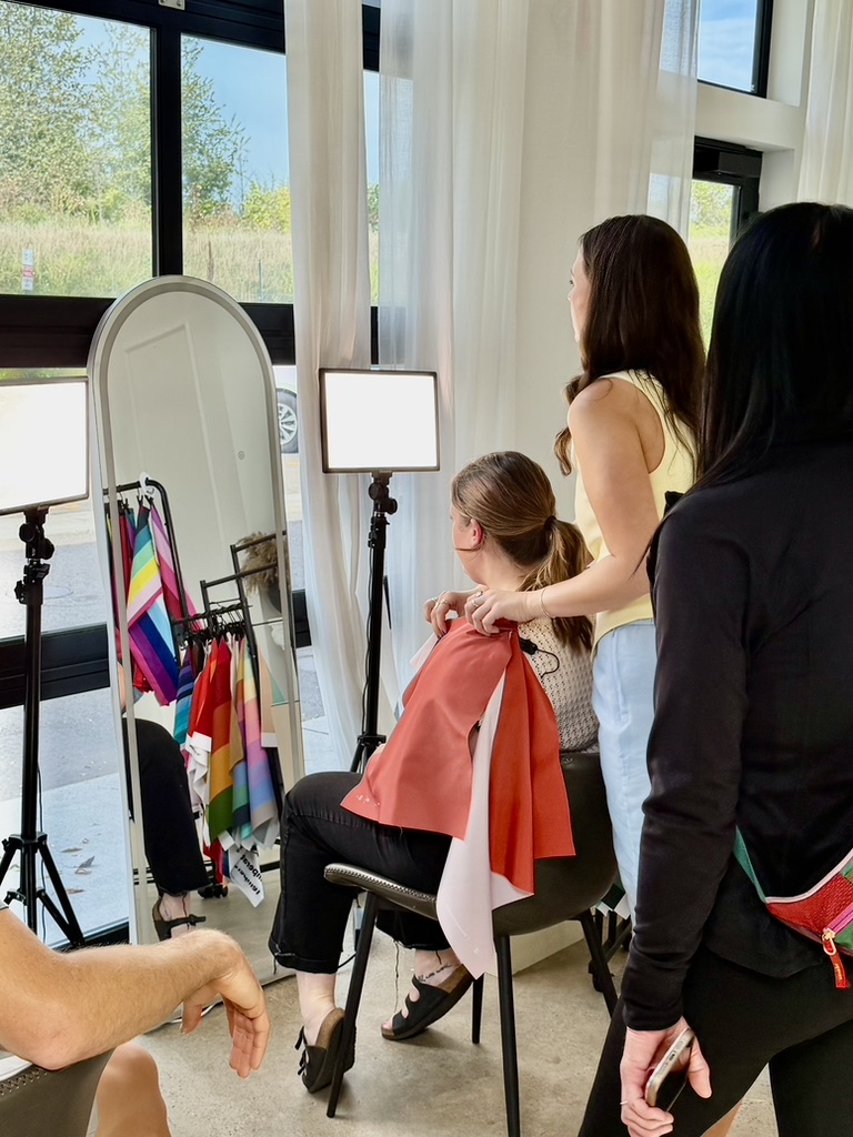 A guest being draped in coral while friends watch in the mirror at a color party