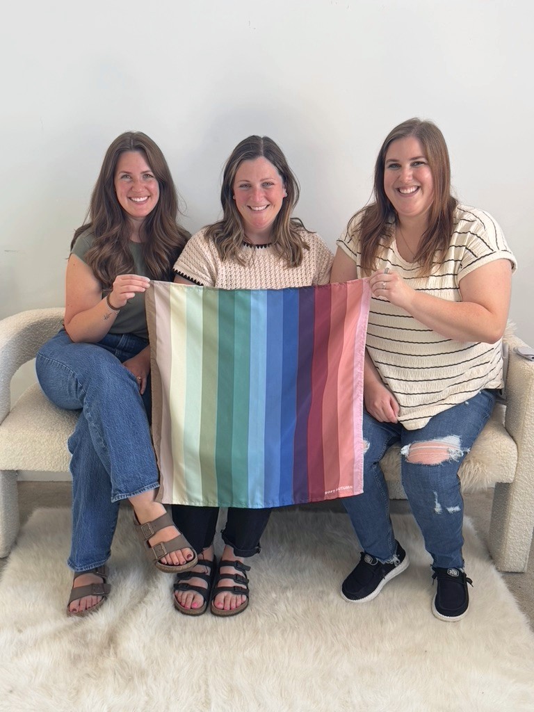 Three friends holding a Soft Autumn palette at a color party